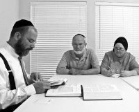 Rabbi Yaakov Rich leads his �Path of the Just� students, including Asher and Rivka Jacobs, in a discussion at Congregation Toras Chaim last week.<br><i>Photo: Steve Israel</i>